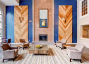 Thumbnail 4 of 25 - a living room with blue walls and a brick fireplace