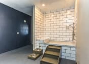 Thumbnail 7 of 25 - a small bathroom with white tiles and a black wall