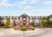 Thumbnail 2 of 25 - an exterior view of an apartment building with a circular driveway