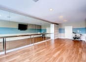 Thumbnail 5 of 25 - a workout room with mirrored walls and a wood floor