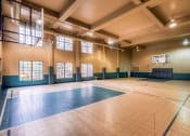 Thumbnail 10 of 25 - a basketball court in an empty gym with a basketball hoop