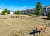 Thumbnail 5 of 21 - A park with a bench and a fence in front of a row of houses.