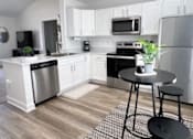 Thumbnail 16 of 21 - A kitchen with a black and white rug on the floor.