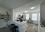 Thumbnail 14 of 21 - A kitchen with white countertops and black stools.