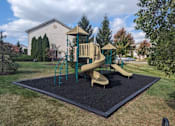 Thumbnail 11 of 21 - A playground with a slide and a wooden structure.