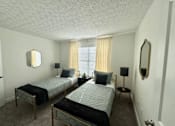 Thumbnail 9 of 21 - Two twin beds in a room with a mirror and a window.