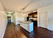 Thumbnail 3 of 18 - A kitchen with dark wood floors and white cabinetry.