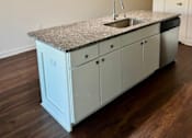 Thumbnail 4 of 18 - A kitchen with a granite countertop and a sink.