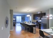 Thumbnail 3 of 12 - a kitchen and dining room with stainless steel appliances and wood flooring