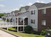 Thumbnail 9 of 12 - A row of houses with a white fence in front.