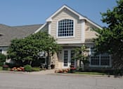 Thumbnail 4 of 8 - A house with a grey roof and a white door.