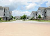 Thumbnail 13 of 13 - A street view of a residential area with apartment buildings on both sides.
