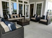 Thumbnail 3 of 13 - A patio with a couch, chairs, and a coffee table.