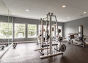 Thumbnail 3 of 17 - A spacious gym with a variety of equipment including a squat rack, bench press, and dumbbells at Twin Fountains Apartments, Mason, OH