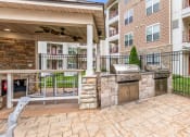 Thumbnail 31 of 63 - the preserve at ballantyne commons spacious outdoor patio with grill and stone wall at Vanguard Crossing, Missouri 63124