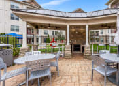 Thumbnail 30 of 63 - a patio with tables and chairs in front of a building at Vanguard Crossing, Missouri 63124
