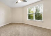 Thumbnail 46 of 63 - an empty bedroom with a large window and carpeting at Vanguard Crossing, Missouri 63124