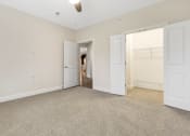 Thumbnail 44 of 63 - an empty living room with white doors and carpet at Vanguard Crossing, St. Louis, Missouri