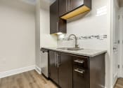 Thumbnail 43 of 63 - a kitchen with dark cabinets and a sink and a faucet at Vanguard Crossing, St. Louis, 63124