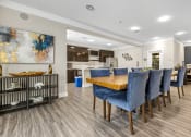 Thumbnail 36 of 63 - a dining room with blue chairs and a wooden table at Vanguard Crossing, St. Louis, MO 63124