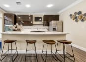 Thumbnail 37 of 63 - a kitchen with a large island with three stools at Vanguard Crossing, St. Louis, 63124