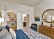 Thumbnail 22 of 52 - a bedroom with a bed and a mirror and a closet at Aster Apartments, Beachwood, OH