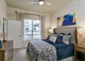 Thumbnail 41 of 52 - a bedroom with a bed and a ceiling fan at Aster Apartments, Beachwood, 44122