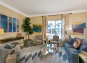Thumbnail 21 of 52 - a living room with a blue couch and a glass coffee table at Aster Apartments, Beachwood Ohio