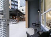 Thumbnail 12 of 52 - a patio with two chairs and a table in front of a door at Aster Apartments, Beachwood Ohio