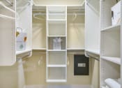 Thumbnail 32 of 52 - a walk in closet with white shelving and shelves and a door at Aster Apartments, Beachwood, 44122