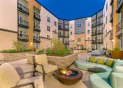 Thumbnail 28 of 52 - an outdoor patio with couches and chairs and a fire pit at Aster Apartments, Ohio