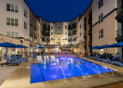 Thumbnail 1 of 52 - a large swimming pool in front of an apartment building at night at Aster Apartments, Beachwood, OH 44122