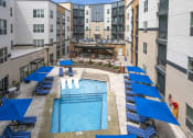 Thumbnail 16 of 52 - an overhead view of an apartment pool with blue umbrellas at Aster Apartments, Ohio