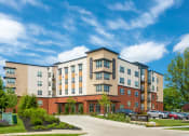 Thumbnail 51 of 52 - a large apartment building with cars parked in front of it at Aster Apartments, Beachwood