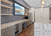 Thumbnail 43 of 52 - A kitchen with a marble countertop and a painting of a lake on the wall at Aster Apartments, Beachwood Ohio