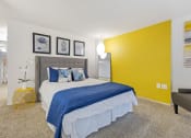 Thumbnail 6 of 28 - a bedroom with a yellow accent wall and a bed at Park 44, St. Louis, 63108