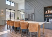 Thumbnail 24 of 36 - a kitchen with a large island and a bar with leather chairs at Statesman Apartments, Franklin, 53132