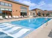 Thumbnail 2 of 36 - a swimming pool in front of a building at Statesman Apartments, Franklin, WI 53132