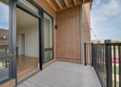 Thumbnail 14 of 36 - a balcony with glass doors and a wooden deck at Statesman Apartments, Franklin, WI 53132
