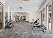 Thumbnail 37 of 52 - A gym with a grey carpet and a fan on the ceiling at Aster Apartments, Beachwood, OH 44122