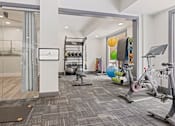 Thumbnail 5 of 52 - A gym with a variety of equipment including a treadmill, exercise balls, and a stationary bike at Aster Apartments, Beachwood, 44122