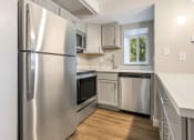 Thumbnail 7 of 28 - a kitchen with stainless steel appliances and white cabinets at Park 44 Apartments in St. Louis, MO, 63108