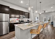 Thumbnail 10 of 56 - A kitchen with a marble countertop and wooden chairs.