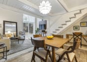 Thumbnail 4 of 28 - a living room with a dining room table and a staircase at Park 44 Apartments in St. Louis, MO, 63108