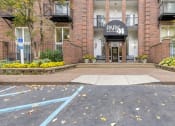 Thumbnail 1 of 28 - the entrance to a brick building with a parking lot in front of it at Park 44 Apartments in St. Louis, MO, 63108