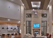 Thumbnail 2 of 40 - a living room with a fireplace and a television at Hunters Creek Apartments, Denton, TX