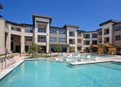 Thumbnail 8 of 40 - a large swimming pool in front of an apartment building at Hunters Creek Apartments, Denton