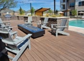 Thumbnail 11 of 40 - a group of chairs on a deck next to a pool at Hunters Creek Apartments, Denton