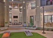 Thumbnail 14 of 40 - a view of a building with a courtyard with grass and a fountain at Hunters Creek Apartments, Denton, TX