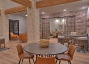 Thumbnail 21 of 40 - a living room with a table and chairs and a brick wall at Hunters Creek Apartments, Texas